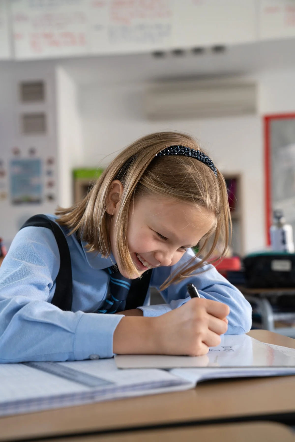 Student writing and smiling
