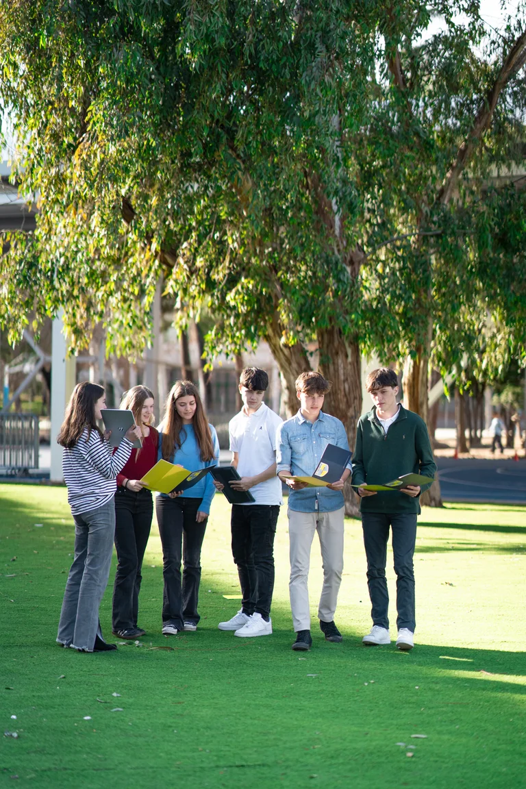 Students with books in the schoolyard
