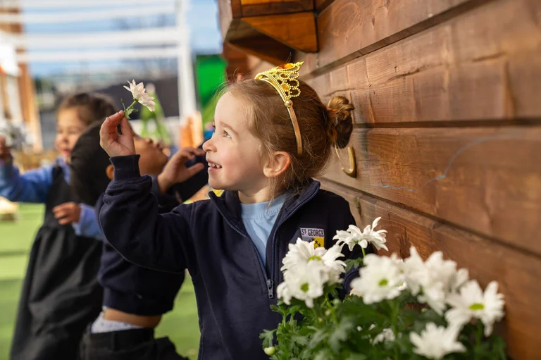 Child smiling with a flower in the hands