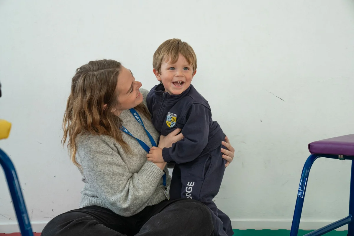 Teacher with a kid smiling