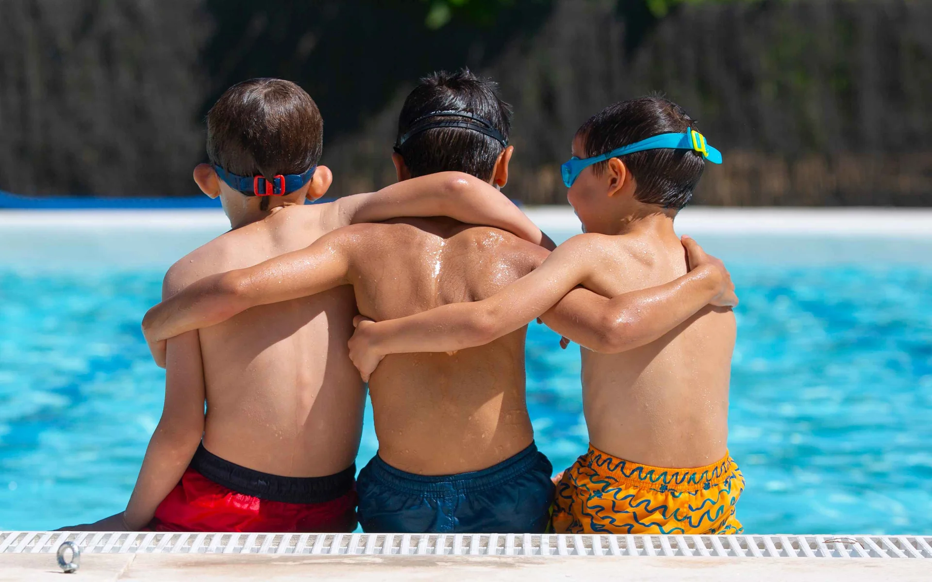Three students hugging during swim lesson