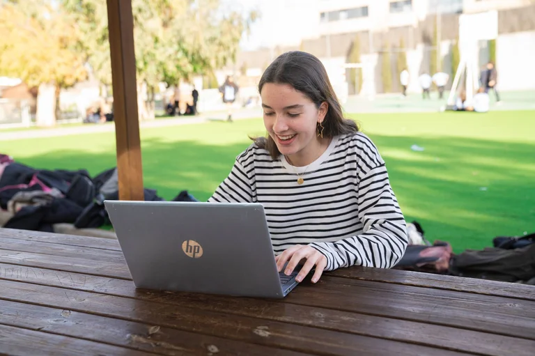 Student smiling in front of a computer