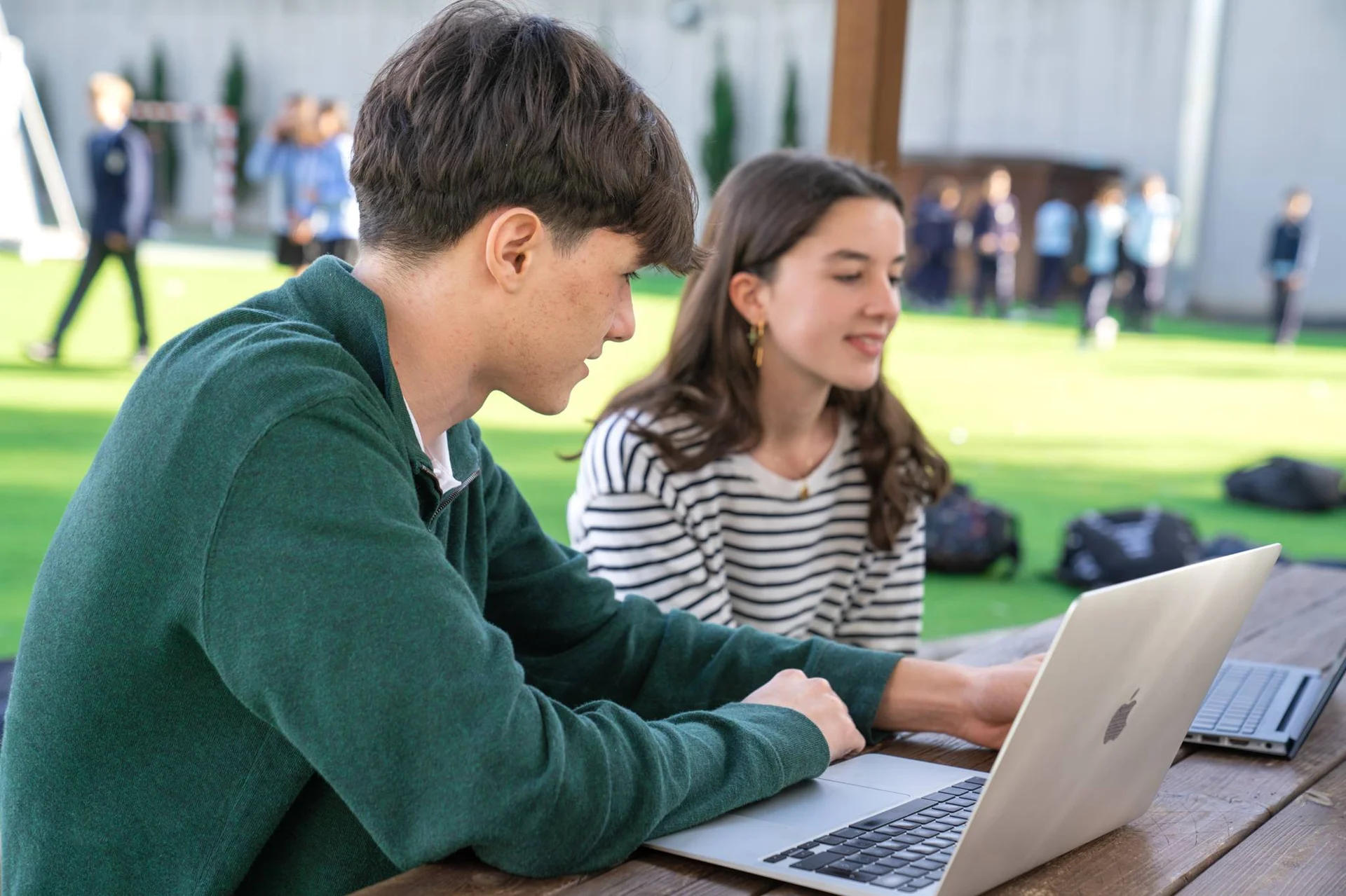 Two students at the computer in the schoolyhard