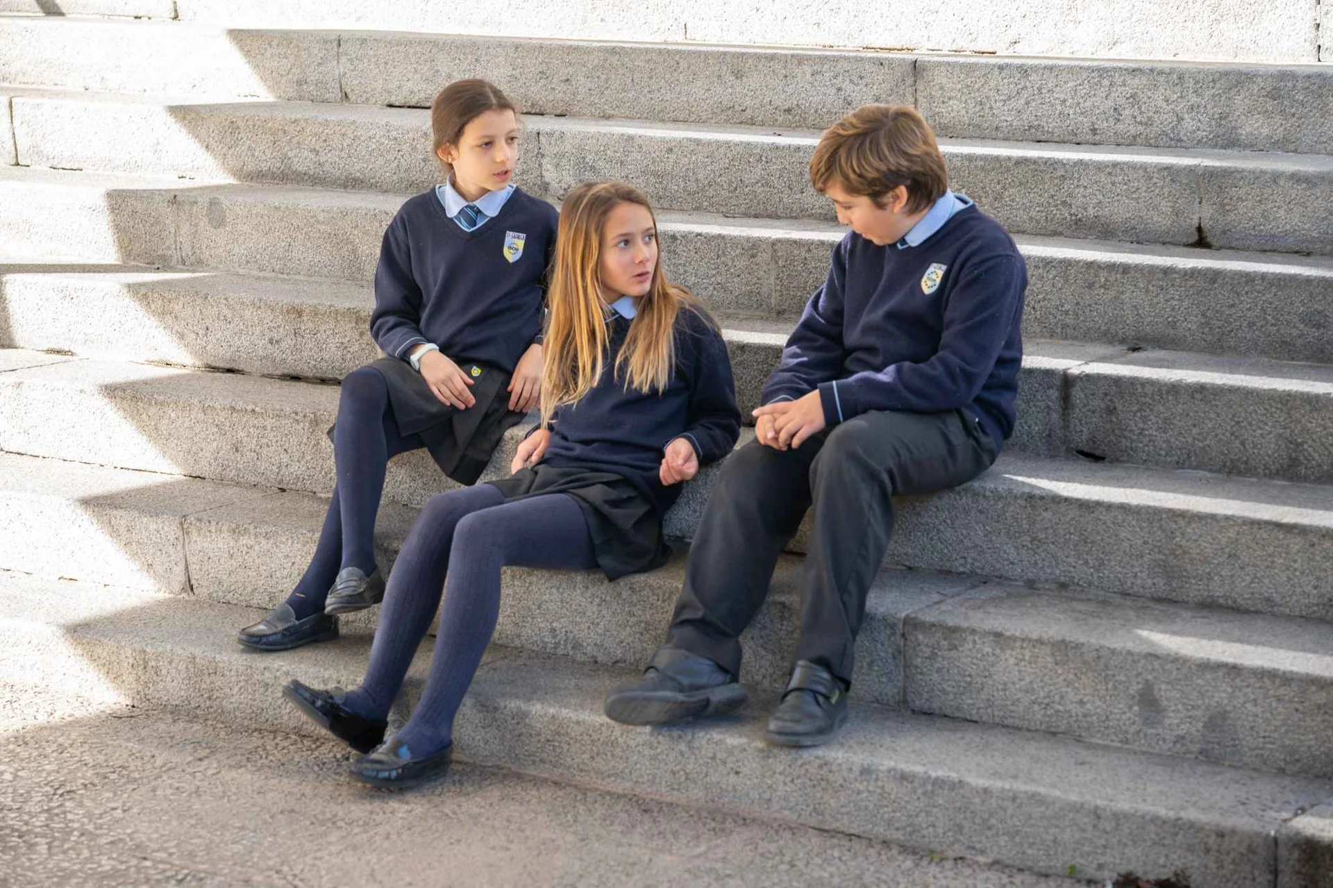 Three students talking on the stairs