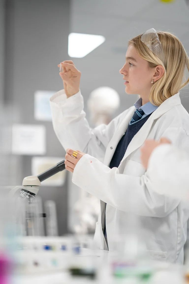 Student looking at a piece of glass during chemistry class