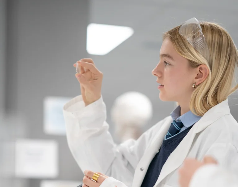 Student looking at a piece of glass during chemistry class