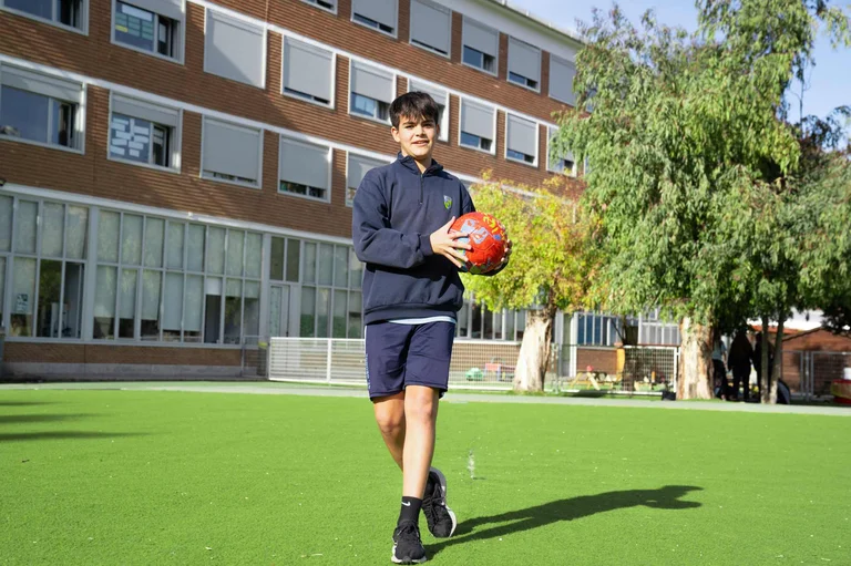 Student in uniform holding a soccer ball